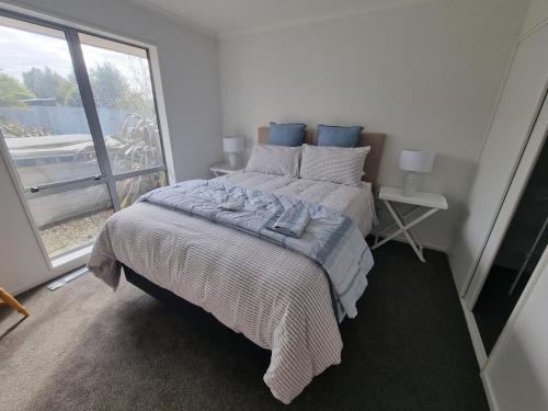 a bedroom with a bed and a large window at Home away from home in Rolleston in Rolleston