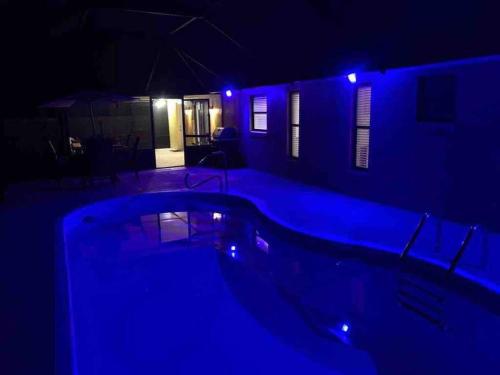 a swimming pool at night with blue lights at Heated Pool home fenced yard near the beach in Palm Coast