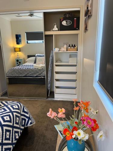 een kleine slaapkamer met een bed en een spiegel bij Bowen Sunrise Retreat Homestay in Bowen