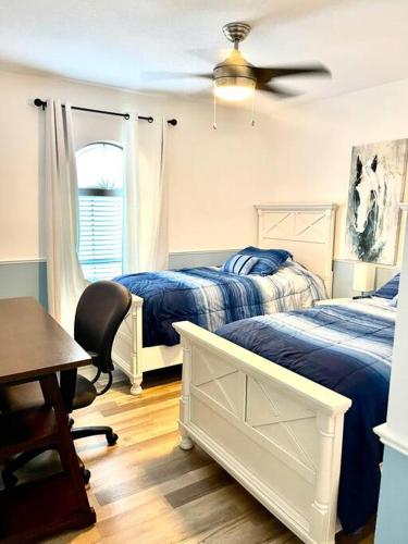 a bedroom with two beds and a ceiling fan at Heated Pool home fenced yard near the beach in Palm Coast
