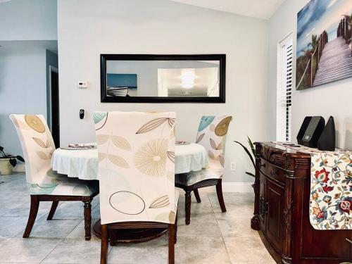 a dining room with a table and chairs and a mirror at Heated Pool home fenced yard near the beach in Palm Coast