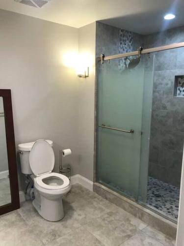 a bathroom with a toilet and a glass shower at Heated Pool home fenced yard near the beach in Palm Coast