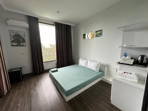 a bedroom with a bed in a room with a window at King Bavi Resort in Ba Vì