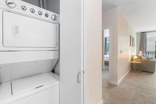 a kitchen with a white refrigerator and a living room at Belltown Perch, explore like a local 99 Walkscore in Seattle