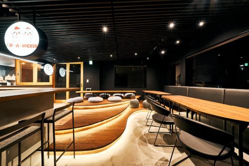 een restaurant met tafels en stoelen en een bar bij Cocts Akihabara in Tokyo