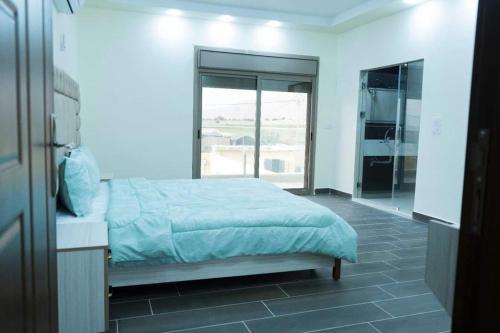1 dormitorio con cama y ventana grande en شاليه سد الموجب, en Al Mara‘ah