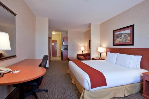 a hotel room with a large bed and a desk at Holiday Inn Express Airdrie, an IHG Hotel in Airdrie