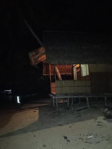 a house at night with a bench in front of it at Nyande Rengkri Guest House in Kri