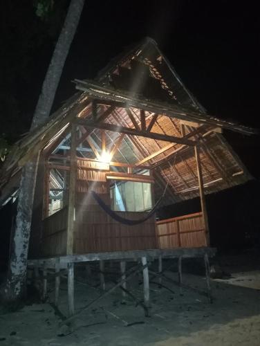 a bamboo house with a hammock in the night at Nyande Rengkri Guest House in Kri