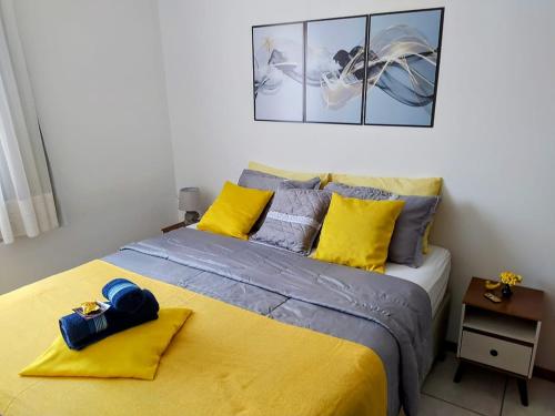 una camera da letto con un letto con lenzuola gialle e grigie di Maria Apê São Mateus l Garagem l WiFi l Térreo l Um minuto do shopping independência a Juiz de Fora