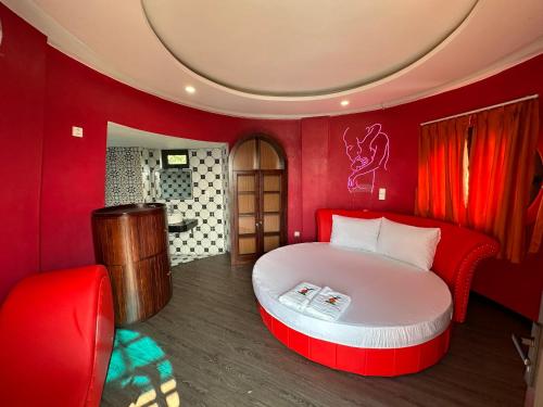 a red bedroom with a bed and a red chair at King Bavi Resort in Ba Vì