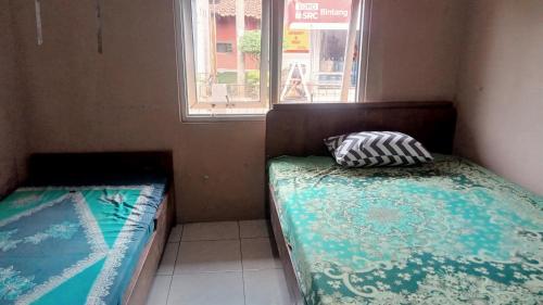 Un pat sau paturi într-o cameră la Bintang Homestay Purwokerto