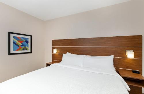a bedroom with a large white bed with wooden headboard at Holiday Inn Express Hotel & Suites Birmingham - Inverness 280 by IHG in Birmingham