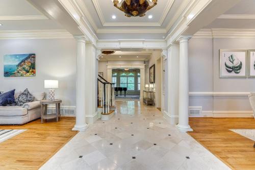 a living room with white columns and a couch at Buford Mansion with Pool about 14 Mi to Lake Lanier in Buford