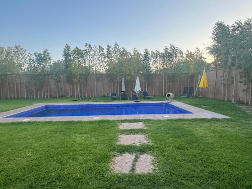 a swimming pool in a yard with a fence at Villa Salah in Marrakech