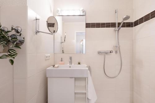 een witte badkamer met een wastafel en een douche bij Panoramablick in Plön