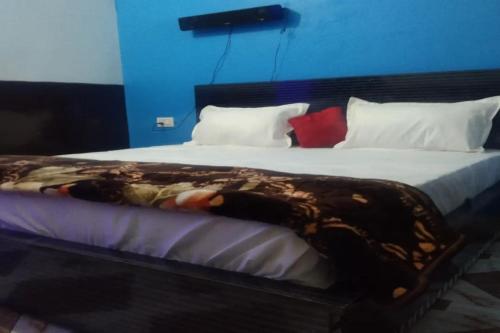 a large bed with a blanket on top of it at OYO Hotel Rosewood in Palwal
