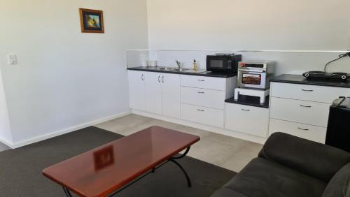 a living room with a coffee table and a microwave at Tonny Cottage in Tongala