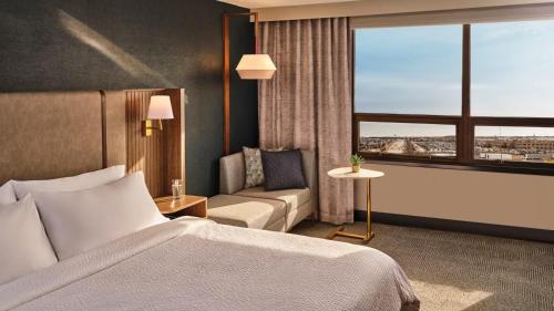 Habitación de hotel con cama, sofá y ventana en Holiday Inn & Suites Monterey Park-Los Angeles en Monterey Park