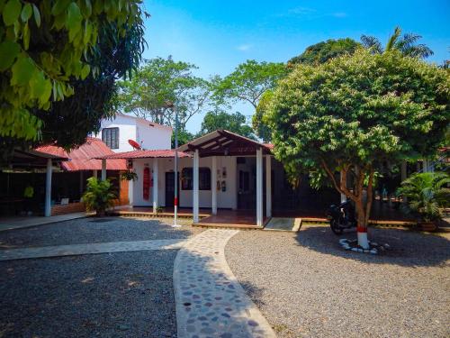 uma casa com uma árvore em frente em Hotel campestre las palmas em Villavicencio