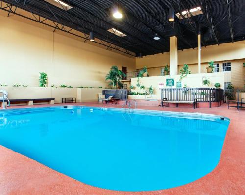 una grande piscina in una stanza con tavoli e sedie di Holiday Inn Blytheville, an IHG Hotel a Blytheville