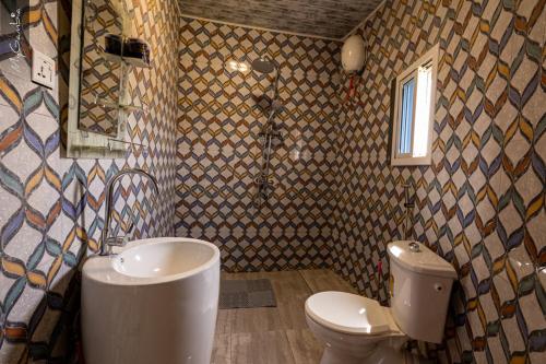 a bathroom with a toilet and a sink and a shower at Bojang River Lodge in Bakau