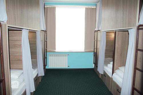 Cette chambre comprend 2 lits superposés et une fenêtre. dans l'établissement All Eyes Hostel, à Kamianets-Podilsky