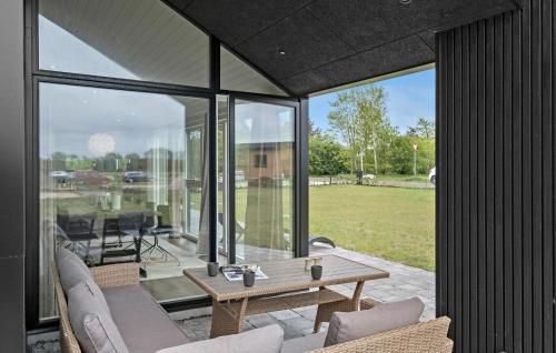 a glass extension of a house with a table and chairs at 4 Bedroom Cozy Home In Hadsund in Hadsund