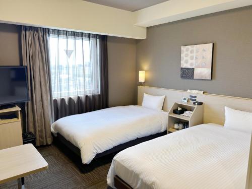 a hotel room with two beds and a television at Hotel Route Inn Isehara Ooyama Inter -Kokudo 246 Gou- in Isehara