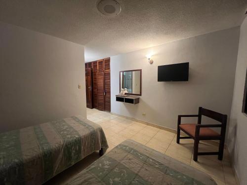 a bedroom with a bed and a chair and a television at Eurohotel in Panama City