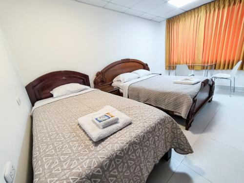 two beds in a hospital room with a towel at SANTA VICTORIA HOUSE in Chiclayo