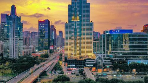 a city skyline with skyscrapers and a freeway at Lux Cabins Hotel Shenzhen in Shenzhen