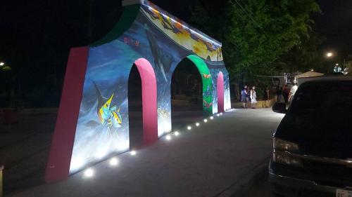 a colorful building with lights on a street at night at Bungalows Maria Teresa in Rincon de Guayabitos