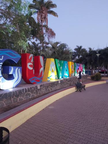 a row of colorful signs on a wall at Bungalows Maria Teresa in Rincon de Guayabitos