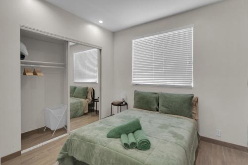 a bedroom with a bed with two green pillows on it at Luxury Three-Bedroom Condo in Los Angeles