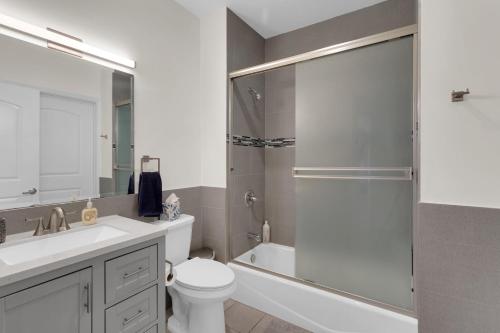 a bathroom with a shower and a toilet and a sink at Luxury Three-Bedroom Condo in Los Angeles