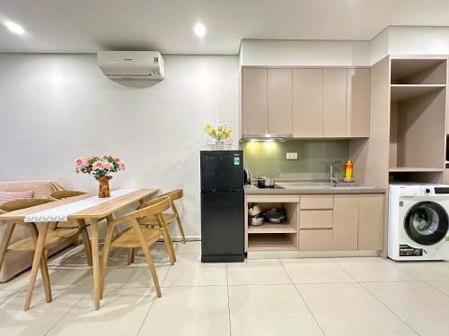 Il comprend une cuisine et une salle à manger avec une table et un réfrigérateur. dans l'établissement The Sóng Vũng Tàu Sunny, à Vung Tau