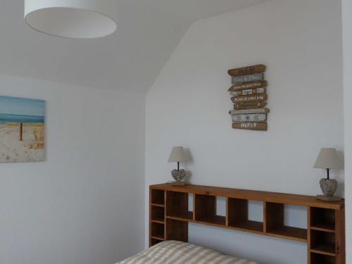 een slaapkamer met een bed en een bord aan de muur bij Maison Cabourg, 4 pièces, 4 personnes - FR-1-794-53 in Cabourg