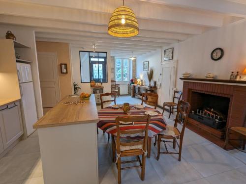 a kitchen and dining room with a table and a fireplace at Moulin Authentique avec Jardin Privé et Activités pour Familles et Amis en Bord de Rivière - FR-1-653-251 in Saint-Mary