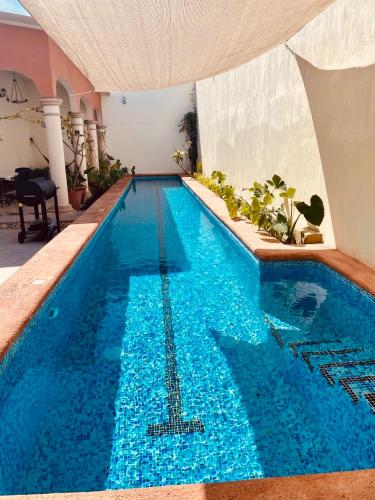 a large swimming pool with blue water in a building at Casa Libertad Tepic in Tepic