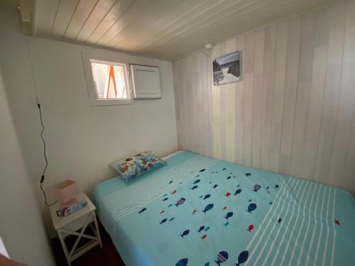 une petite chambre avec un lit avec une couette bleue dans l'établissement T1 cabine centre-ville Arcachon avec parking - FR-1-319-467, à Arcachon