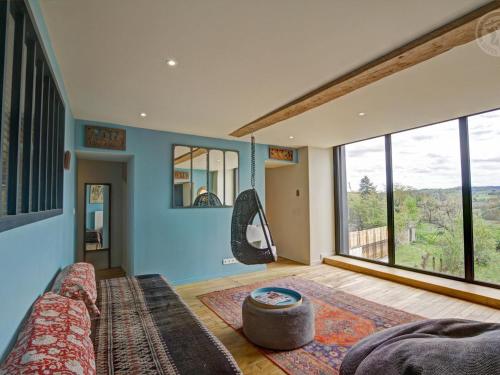 ein Wohnzimmer mit einem Sofa und einem großen Fenster in der Unterkunft Gîte Saint-Symphorien-de-Lay, 5 pièces, 12 personnes - FR-1-496-312 in Saint-Symphorien-de-Lay