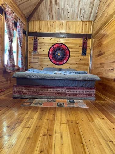 Ce lit se trouve dans un dortoir doté d'un mur en bois. dans l'établissement Homestay Bethel, à Sa Pả
