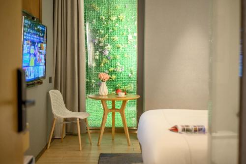 a room with a table and a vase of flowers at Lux Cabins Hotel Shenzhen in Shenzhen