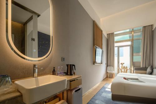 a bathroom with a sink and a bed and a mirror at Lux Cabins Hotel Shenzhen in Shenzhen