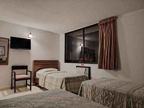 a hotel room with two beds and a window at Eurohotel in Panama City