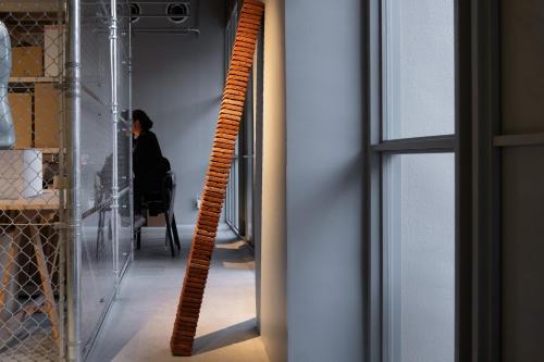a spiral staircase in a room with a person sitting in a chair at KAIKA Tokyo by THE SHARE HOTELS in Tokyo