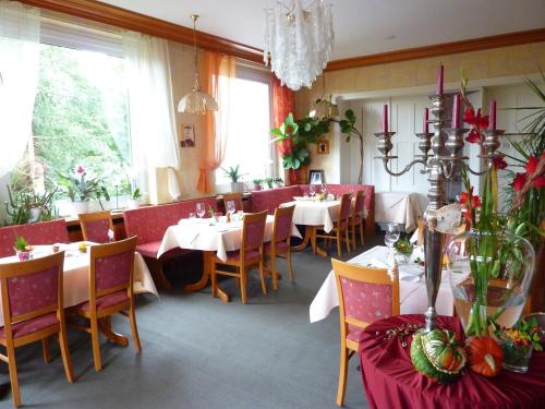 un restaurante con mesas y sillas en una habitación en Hotel Oranien, en Nastätten