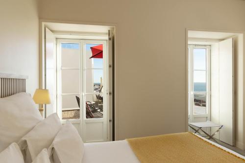 a bedroom with a bed and a view of the ocean at Memmo Alfama - Design Hotels in Lisbon
