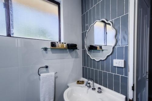 a bathroom with a sink and a mirror at Roydons Motor Inn in Tamworth